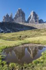 El Tre Cime di Lavaredo / Drei Zinnen se refleja en un lago, Dolomiti di Sesto, Trentino-Alto Adige, Italia - foto de stock