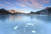 Bolle di ghiaccio sulla superficie ghiacciata del Lago Andossi all'alba Vallespluga, Valtellina, Lombardia, Italia, Europa — Foto stock