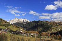 The colorful woods frame the village and the high peaks in autumn Gardena Valley, Trentino-Alto Adige, Italy, Europe — Stock Photo