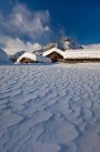 Ветер формирует снег, который упал между традиционными хижинами Альпе Прабелло, Долина Маленко, Валтеллина, Ломбардия, Италия, Европа — стоковое фото