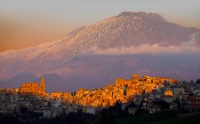 Recalbuto paisaje urbano un volcán Etna en el fondo al atardecer, Sicilia, Italia, Europa - foto de stock