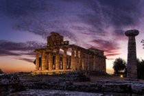 Puesta de sol en el sitio arqueológico de Paestum, Campania, Italia, Europa - foto de stock