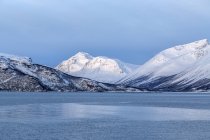 Blue sky and snowy peaks surround the cold sea Lyngen Alps Troms, Lapland, Norway, Europe — Stock Photo