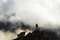 L'uomo in piedi su una roccia circondata da nuvole sul Lagazuoi, Dolomiti, Italia — Foto stock