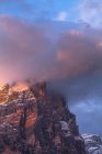 Alpenglow and clouds highlighting Tofana di Rozes, Cortina d 'Ampezzo, Dolomites, Veneto, Italy — стоковое фото