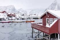 Mer glacée et pics enneigés autour des maisons typiques appelées rorbu et bateaux de pêche Hamn paysage Lofoten Islands, Norvège du Nord, Europe — Photo de stock