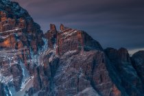 Alpenglow and clouds highlighting Tofana di Rozes from Giau Pass, Cortina d 'Ampezzo, Dolomites, Veneto, Italy — стоковое фото