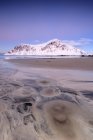 Céu rosa e picos nevados enquadram a praia surreal de Skagsanden ao pôr do sol Flakstad Paisagem do condado de Nordland, Lofoten Islands, Noruega, Europa — Fotografia de Stock