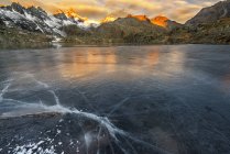 Paisaje del amanecer en el Lago Negro, en el fondo Grupo Presanella soleado, Valle Nambrone, Parque Natural Adamello Brenta, Trentino-Alto Adigio, Italia - foto de stock