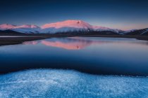 Bela paisagem em Castelluccio di Norcia durante um pôr-do-sol congelado no Monte Redentore refletido no lago, Úmbria, Itália, Europa — Fotografia de Stock