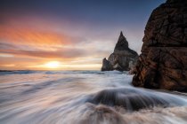 The fiery sky at sunset is reflected on the ocean waves and cliffs , Praia da Ursa landscape, Cabo da Roca Colares, Sintra, Portugal, Europe — Stock Photo