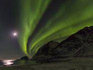 Luces boreales sobre Haukland Beach, isla Vestvagoy. Las islas Lofoten en el norte de Noruega durante el invierno. Europa, Escandinavia, Noruega, febrero - foto de stock