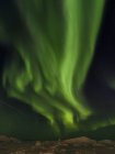 Luces boreales sobre la orilla de la bahía congelada de Disko. Town Ilulissat at the shore of Disko Bay in West Greenland. El fiordo de hielo cercano está catalogado como patrimonio mundial de la UNESCO. América, América del Norte, Groenlandia, Dinamarca - foto de stock