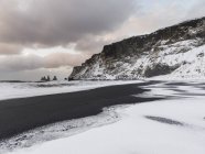 A costa do Atlântico Norte perto de Vik y Myrdal durante o inverno. Praia vulcânica preta com o mar empilha Reynisdrangar. Europa, Norte da Europa, Escandinávia, Islândia, Fevereiro — Fotografia de Stock