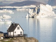 La città di Uummannaq nel nord della Groenlandia occidentale, situata su un'isola nel sistema del fiordo di Uummannaq, sullo sfondo della penisola di Nuussuaq (Nugssuaq). America, Nord America, Groenlandia — Foto stock