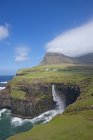 A cachoeira Mulafossur perto de Gasadalur, um dos marcos das Ilhas Faroé. A ilha Vagar, parte das Ilhas Faroé no Atlântico Norte. Ilhas Faroé, Dinamarca, Europa — Fotografia de Stock