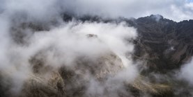 Национальный парк Гора Кения в высокогорье центральной Кении, внесенный в список Всемирного наследия ЮНЕСКО. Облачный пейзаж в центральной части горы Кения. Пики Батиан (5199м) и Нелион на горе. Кенийский хребет - это вымерший вулкан и второй по высоте пик. — стоковое фото