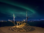 Solfar, a landmark of  Reykjavik. Solfar  icelandic for Sun Voyager is a sculture made of stainless steel in the harbour of Reykjavik made be the artist Jon Gunnar Arnason.  Night shot with northern lights. europe, northern europe, iceland,  February — Stock Photo