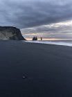 Узбережжя Північної Атлантики біля Vik у Мирдала взимку. Пляж під час сходу сонця з морськими стеками називається Рейддрангар. Європа, Північна Європа, Скандинавії, Ісландії, Лютий — стокове фото