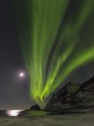 Luces boreales sobre Haukland Beach, isla Vestvagoy. Las islas Lofoten en el norte de Noruega durante el invierno. Europa, Escandinavia, Noruega, febrero - foto de stock