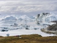 Туристы, любующиеся фьордом. Ilulissat Icefjord также назывался kangia или Ilulissat Kangerlua. Ледяной фьорд включен в список Всемирного наследия ЮНЕСКО. Америка, Северная Америка, Гренландия, Дания — стоковое фото