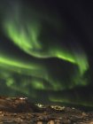 Northern Lights sobre a cidade e congelado Disko Bay. Cidade Ilulissat na costa da Baía de Disko, na Groenlândia Ocidental, centro de turismo, administração e economia. O fiorde de gelo nas proximidades está listado como patrimônio mundial da UNESCO. América, América do Norte, Groenlândia, Den — Fotografia de Stock