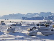 Ciudad Uummannaq durante el invierno en el norte de Groenlandia. Naves en el puerto congelado. América, América del Norte, Dinamarca, Groenlandia - foto de stock