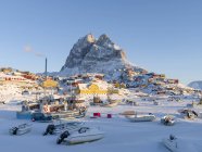 Ciudad Uummannaq durante el invierno en el norte de Groenlandia. Naves en el puerto congelado. América, América del Norte, Dinamarca, Groenlandia - foto de stock