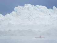 Kayak en la niebla frente a enormes icebergs. Ilulissat Icefjord también llamado kangia o Ilulissat Kangerlua en Disko Bay. El fiordo de hielo está catalogado como patrimonio mundial de la UNESCO. América, América del Norte, Groenlandia, Dinamarca - foto de stock