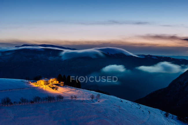 Pequeña aldea en la colina al amanecer, Ecchelen, Stoccareddo, Altopiano de Asiago, Veneto, Italia - foto de stock