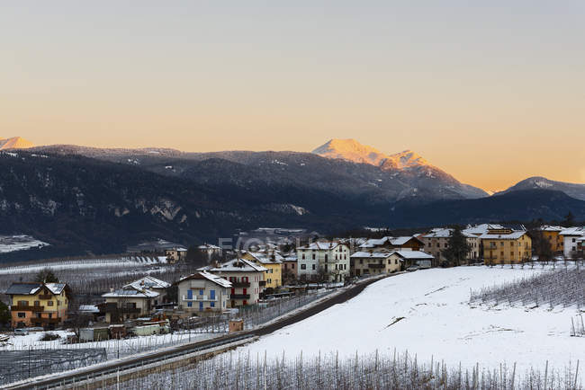 Salida del sol en Romeno Village y Luco Mount en un día de invierno, Non Valley, Trentino-Alto Adige, Italia - foto de stock