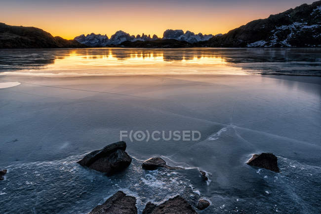 Les Dolomites de Brenta en hiver se reflètent dans la glace du lac Noir à l'aube, vallée de Nambrone, parc naturel Adamello Brenta, Trentin-Haut-Adige, Italie — Photo de stock