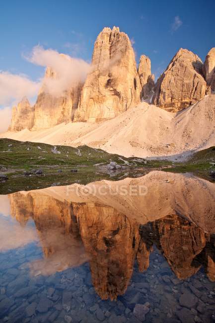 The Three peaks of Lavaredo are reflected into the small lake at sunset, near Locatelli refuge, Tre cime di Lavaredo, Dolomites, eastern Alps, Trentino-Alto Adige, Italy — Stock Photo