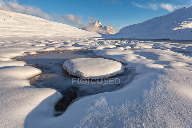 Mondeval nevado con el lago helado de Baste, Dolomitas, Veneto, Italia - foto de stock