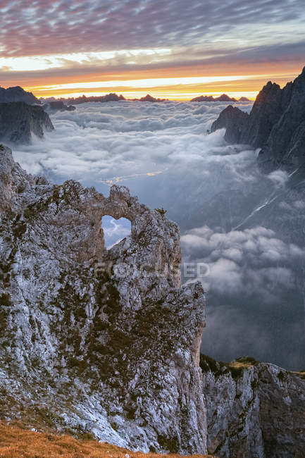 Colorful sunrise in front of the heart shaped arch of stone in the Pale of the Balconies, Pala group, Agordino, Dolomites, Veneto, Italy — Stock Photo