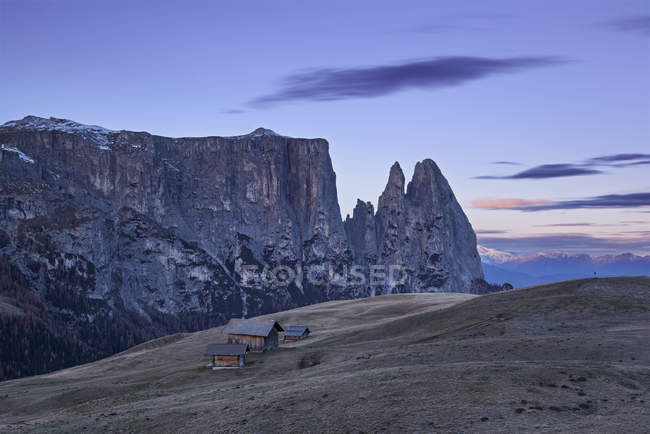 Charakteristische Berghütten mit den Gipfeln des Sciliar / Schlern im Hintergrund, Seiser Alm, Dolomiten, Trentino-Alto adige, Italien — Stockfoto