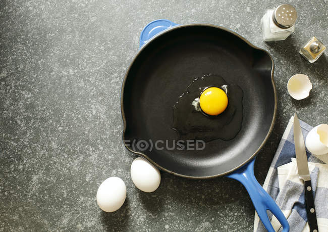 Сырое куриное яйцо в сковороде, вид сверху — стоковое фото