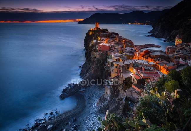 Veduta del paese durante il tramonto, con alberi in primo piano e il mare sullo sfondo, Vernazza, Parco Nazionale delle Cinque Terre, Liguria, Italia — Foto stock