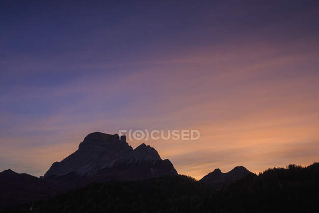 El cielo se vuelve rosado al atardecer en la cumbre rocosa del Monte Pelmo, Cadore, Zoldo, Dolomitas, Veneto, Italia, Europa - foto de stock