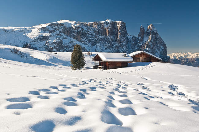 Les cabanes traditionnelles des Dolomites après une chute de neige hivernale donnent sur les paysages du Groupe Sciliar, Siusi, Dolomites occidentales, Trentin-Haut-Adige, Italie, Europe — Photo de stock
