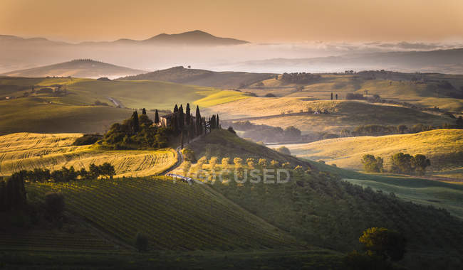 Sunrise over the farmhouse and the hills, Podere Belvedere, San Quirico d 'Orcia, Val d' Orcia, Tuscany, Italy, Europe — стоковое фото