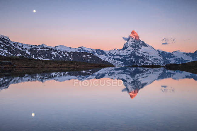 Tthe Matterhorn ao nascer do sol refletido em Stellisee, vale de Zermatt, Zermatt, Cantão de Valais, Suíça, Europa — Fotografia de Stock
