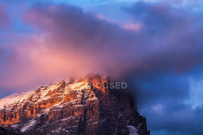 Alpenglow and clouds highlighting Tofana di Rozes, Cortina d'Ampezzo, Dolomites, Veneto, Italy — Stock Photo