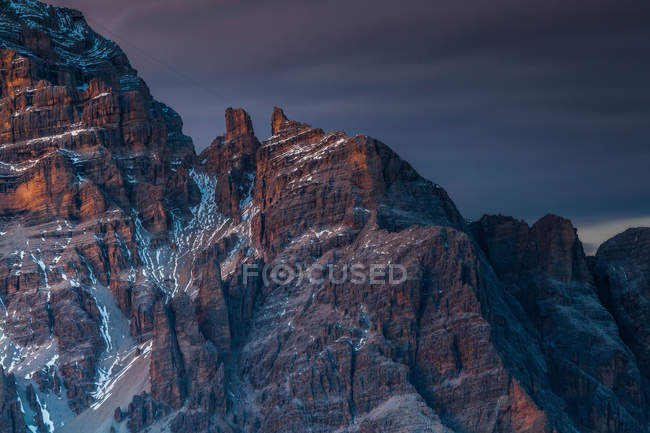 Alpenglow and clouds highlighting Tofana di Rozes from Giau Pass, Cortina d 'Ampezzo, Dolomites, Veneto, Italy — стоковое фото