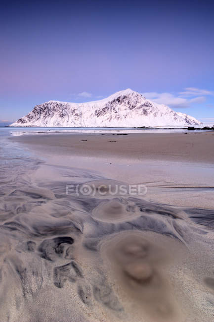 Céu rosa e picos nevados enquadram a praia surreal de Skagsanden ao pôr do sol Flakstad Paisagem do condado de Nordland, Lofoten Islands, Noruega, Europa — Fotografia de Stock