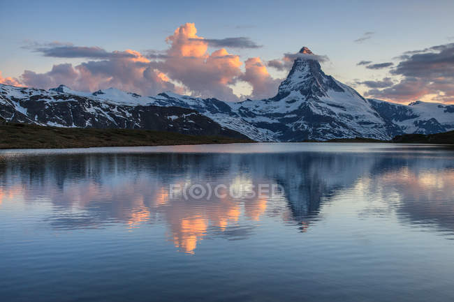El Matterhorn al atardecer reflejado en Stellisee, Zermatt valley, Zermatt, Canton of Valais, Suiza, Europa - foto de stock