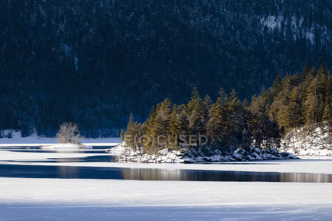 Lago Eibsee durante el invierno con la cordillera de Wetterstein como telón de fondo cerca de Garmisch-Partenkirchen en la Tierra Werdenfelser (región werdenfels), Baviera, Alemania, Europa - foto de stock