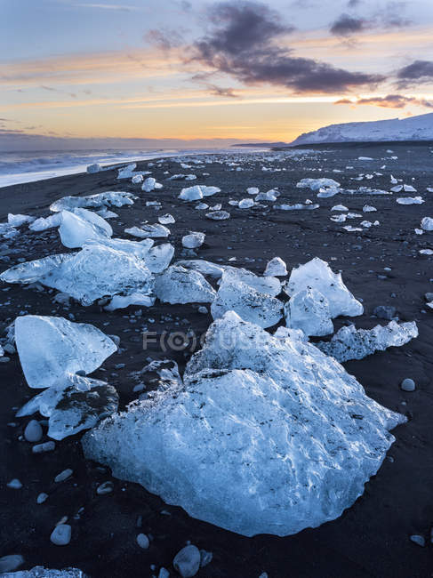 Iceberg en la playa vulcanica negra. Playa del Atlántico Norte de la laguna de hielo Joekulsarlon en el glaciar Breithamerkurjoekull, Vatnajoekull NP. Europa, norte de Europa, iceland, marcha - foto de stock