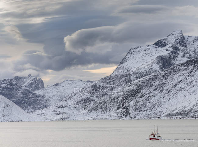 Montañas de Moskenesoya subiendo sobre Selfjorden y Torsfjorden cerca del pueblo Fredvang, visto desde Flakstadoya. Las islas Lofoten en el norte de Noruega durante el invierno. Europa, Escandinavia, Noruega, febrero - foto de stock