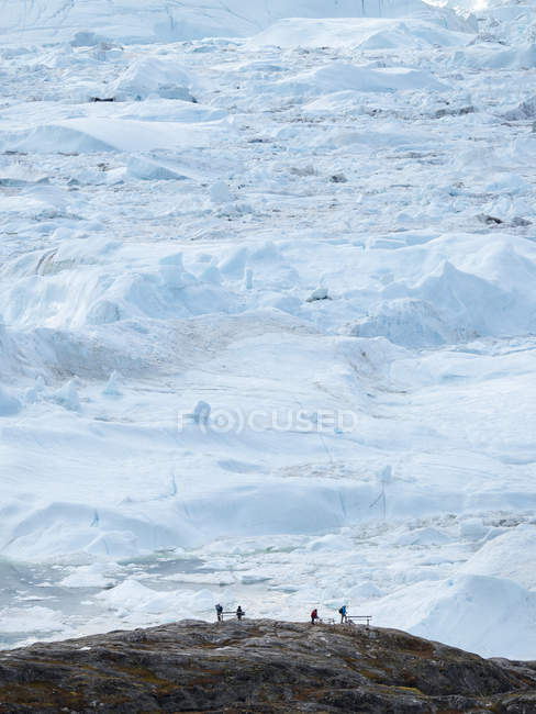 Turistas admirando el fiordo. Ilulissat Icefjord también llamado kangia o Ilulissat Kangerlua. El fiordo de hielo está catalogado como patrimonio mundial de la UNESCO. América, América del Norte, Groenlandia, Dinamarca - foto de stock
